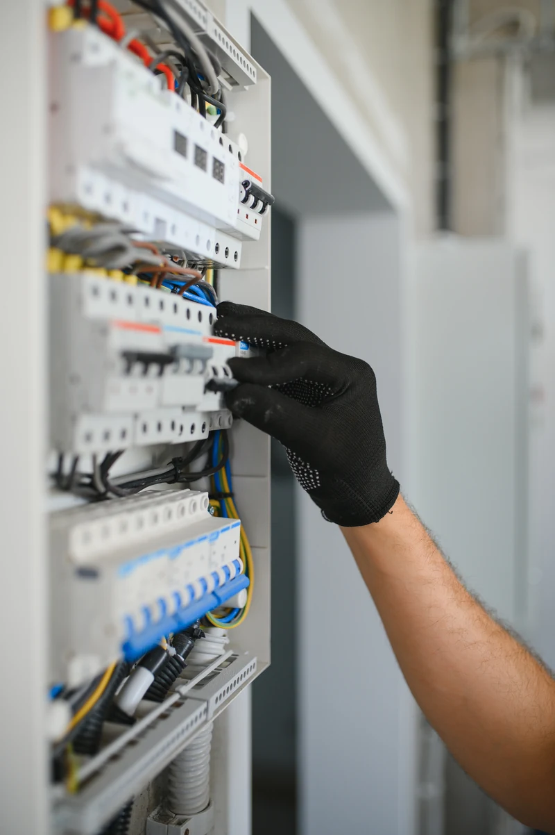 Technik sprawdza tablicę bezpiecznikową na ścianie w mieszkaniu